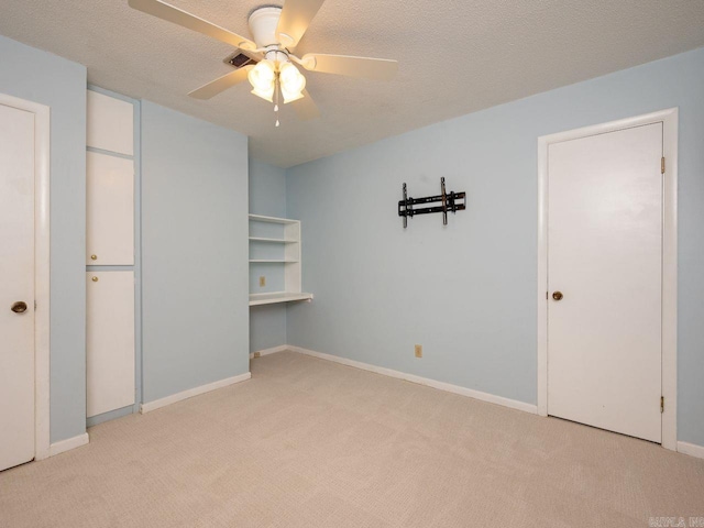 unfurnished bedroom featuring baseboards, a ceiling fan, carpet flooring, and a textured ceiling