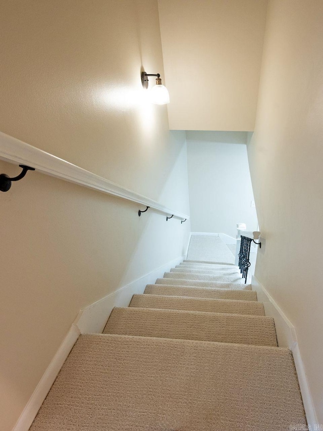 staircase with baseboards and carpet