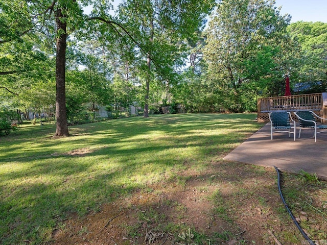 view of yard with a wooden deck and a patio