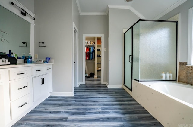 bathroom with crown molding, vanity, a shower stall, wood finished floors, and a bath