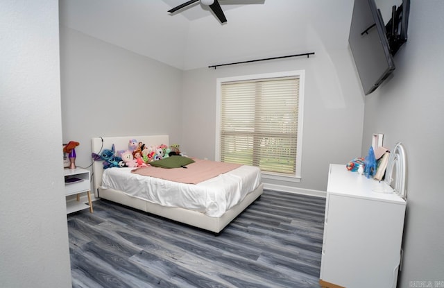 bedroom with baseboards, a ceiling fan, dark wood finished floors, and vaulted ceiling