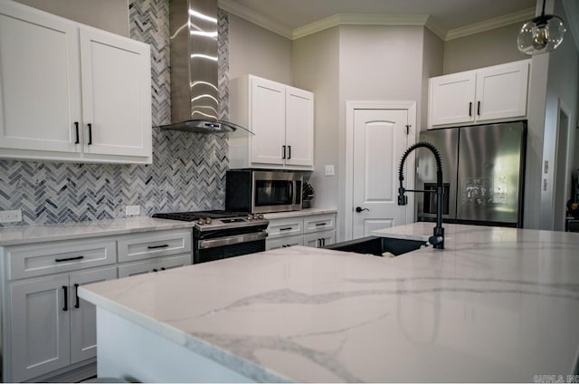 kitchen featuring white cabinets, tasteful backsplash, wall chimney range hood, and stainless steel appliances