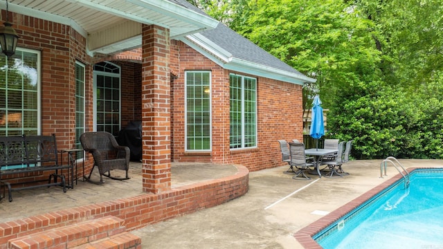 view of patio / terrace with outdoor dining area and an outdoor pool