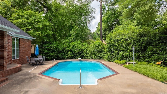 pool with a patio and outdoor dining area