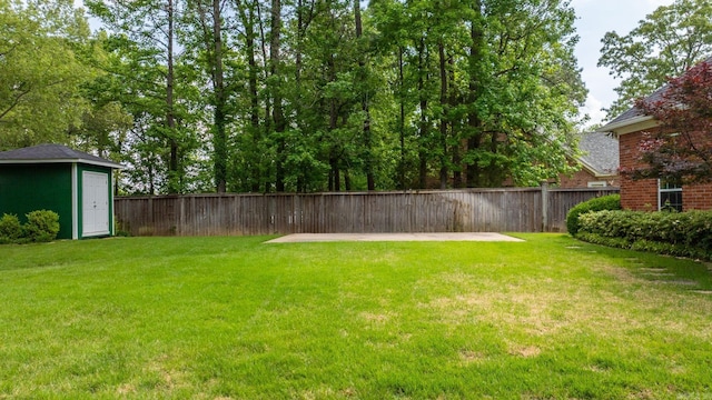 view of yard featuring fence, a patio, an outbuilding, and a storage shed