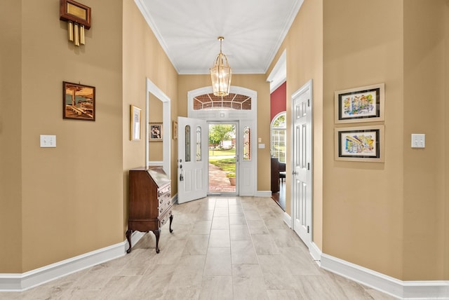 entryway with baseboards, an inviting chandelier, and ornamental molding