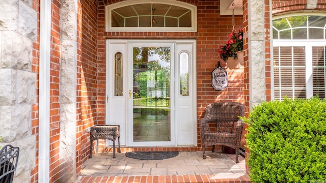 view of exterior entry featuring brick siding