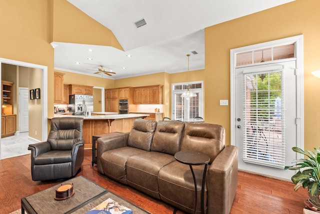 living area with ceiling fan, visible vents, lofted ceiling, light wood-style floors, and recessed lighting