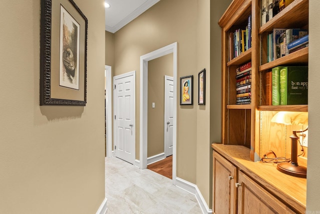 hall featuring crown molding and baseboards