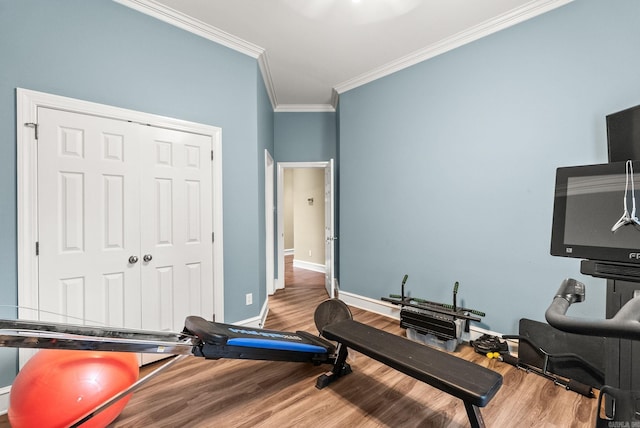 workout room with baseboards, ornamental molding, and wood finished floors