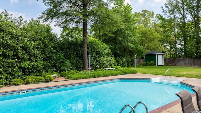 outdoor pool with a yard, fence, an outdoor structure, and a storage unit