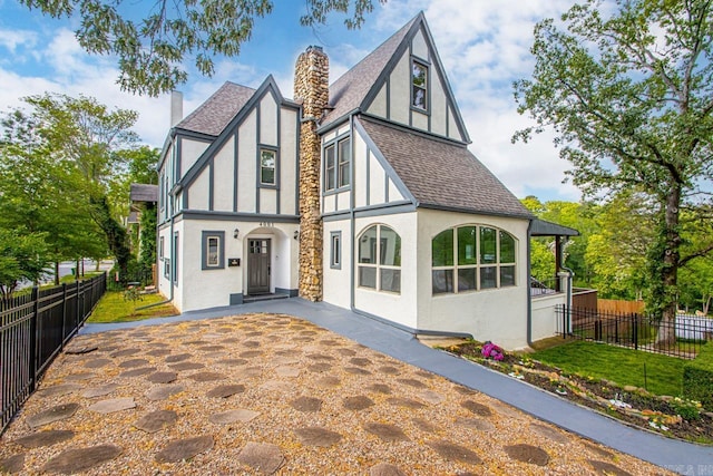 view of front of home featuring roof with shingles, stucco siding, and a chimney