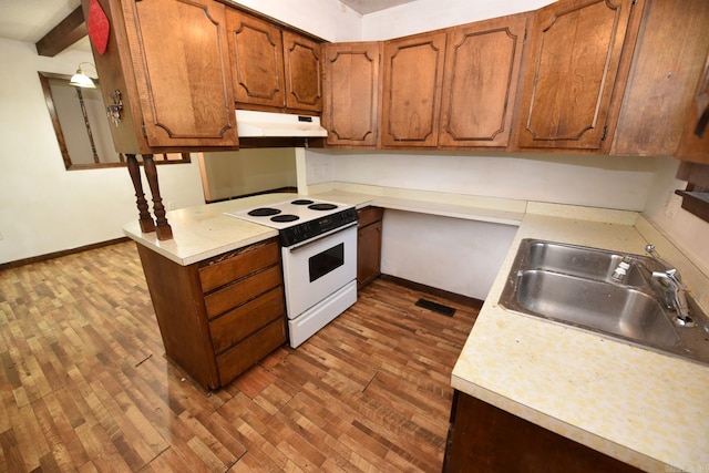 kitchen featuring visible vents, white electric range, light countertops, a sink, and dark wood finished floors