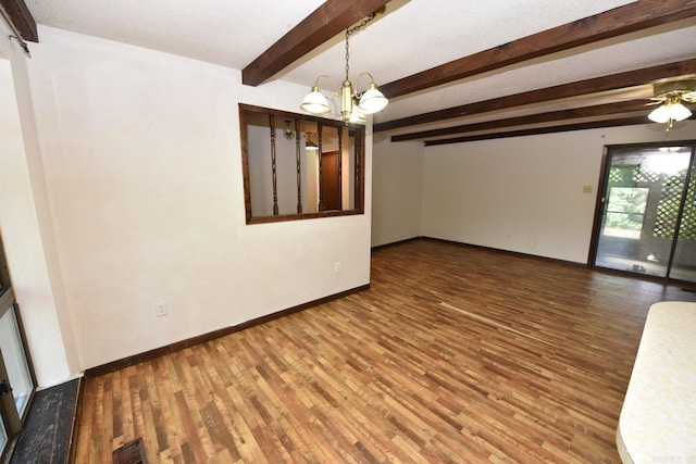 unfurnished room with an inviting chandelier, baseboards, beamed ceiling, and wood finished floors