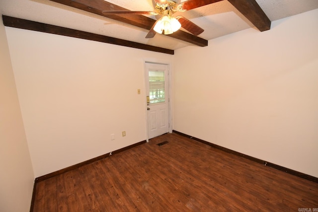 empty room featuring beam ceiling, a ceiling fan, baseboards, dark wood-type flooring, and visible vents