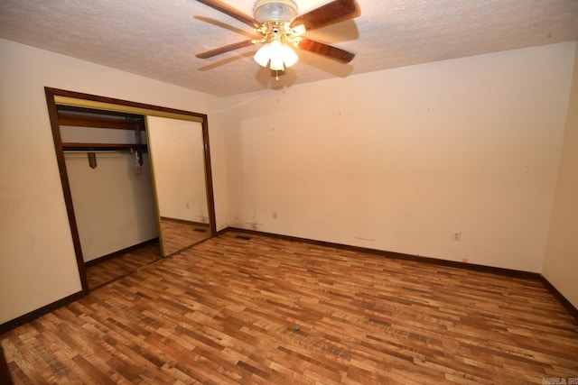unfurnished bedroom with baseboards, a textured ceiling, and wood finished floors