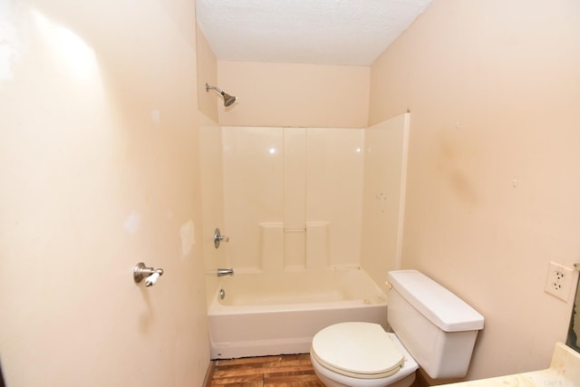 bathroom with  shower combination, a textured ceiling, wood finished floors, and toilet