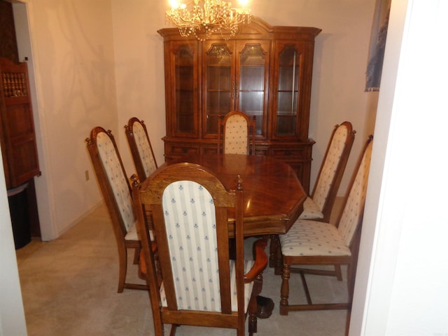 dining room featuring light colored carpet and a notable chandelier