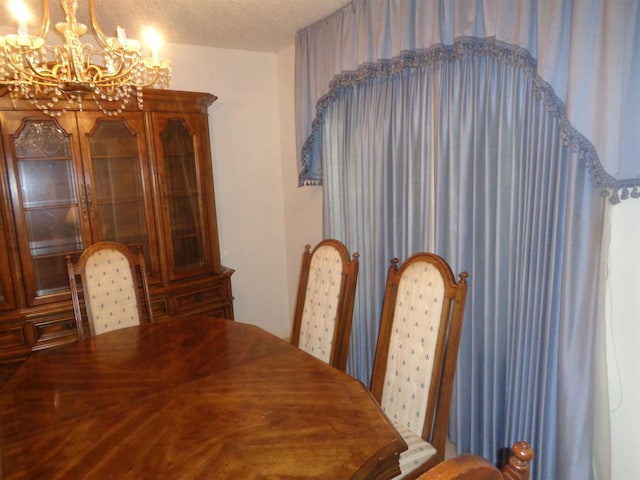 dining area with a textured ceiling and a chandelier