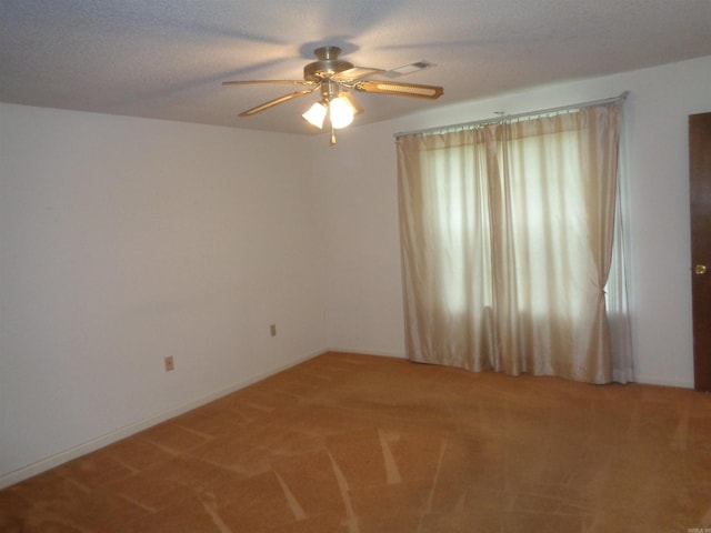 spare room with a ceiling fan and light carpet