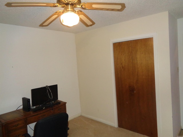 office space featuring a textured ceiling, ceiling fan, and light colored carpet
