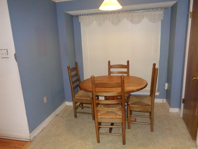 dining space with light floors and baseboards