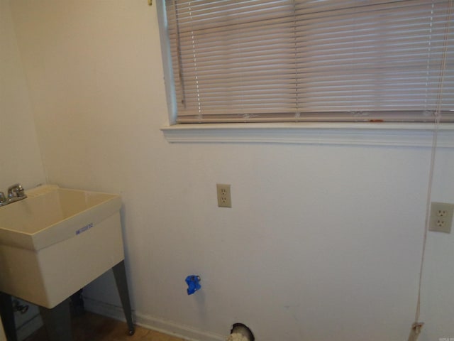 washroom with a sink and baseboards