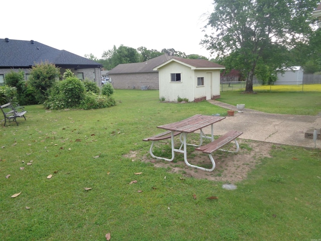 view of yard with fence and an outdoor structure