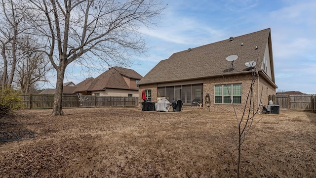 5485 Viney Creek Ln, Jonesboro, AR 72404 - rear view of house with brick siding, a fenced backyard, a shingled roof, and central AC
