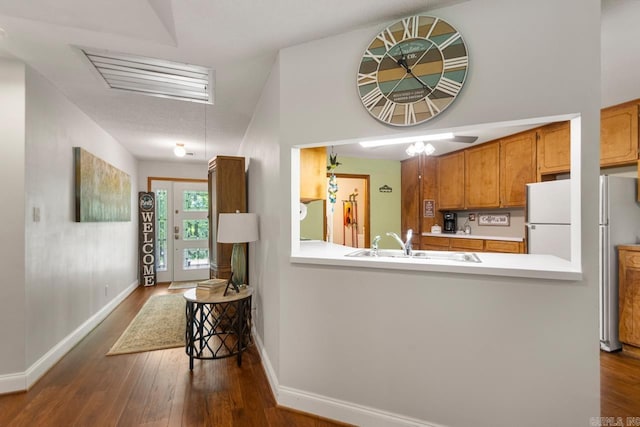 68 Tanner Dr, Bigelow, AR 72016 - interior space featuring dark wood-type flooring, freestanding refrigerator, a sink, and light countertops