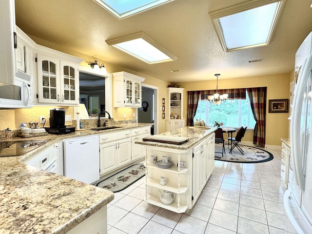 kitchen with a kitchen island, open shelves, a sink, a notable chandelier, and white appliances