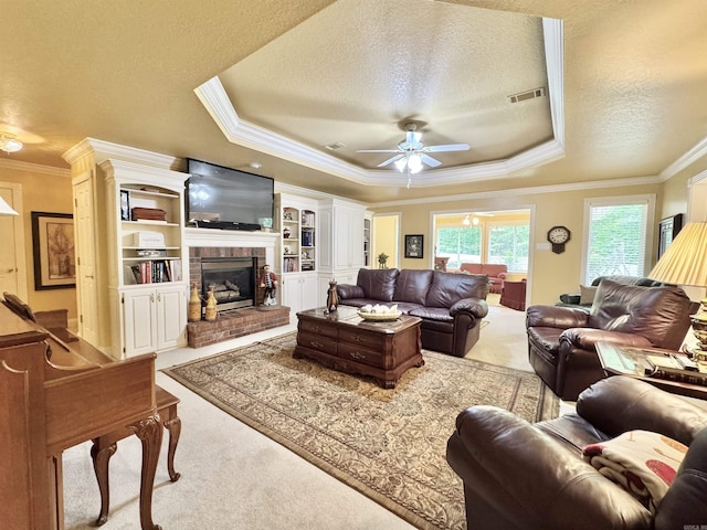 carpeted living area featuring crown molding, ceiling fan, a textured ceiling, a tray ceiling, and visible vents