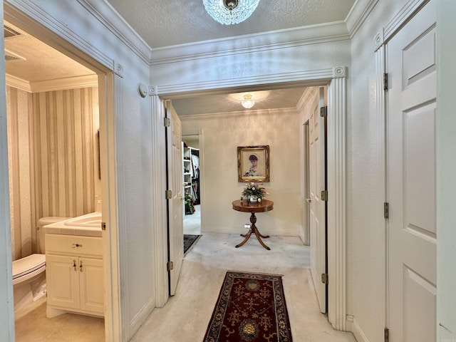 hall featuring crown molding, a textured ceiling, and light colored carpet