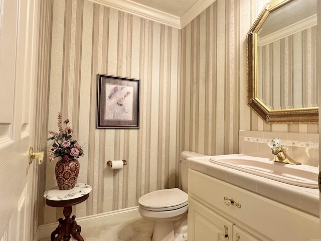 half bath with toilet, wallpapered walls, ornamental molding, and vanity