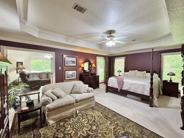 carpeted bedroom featuring crown molding, a raised ceiling, a textured ceiling, and visible vents