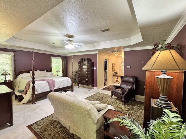 bedroom with visible vents, a tray ceiling, a textured ceiling, and light colored carpet
