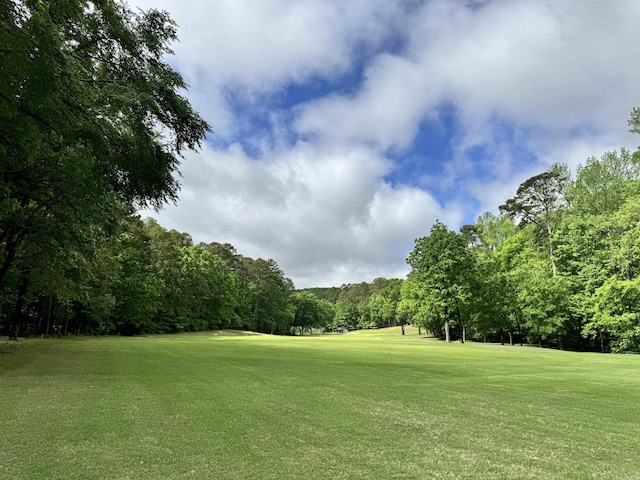 view of property's community with a lawn and view of golf course