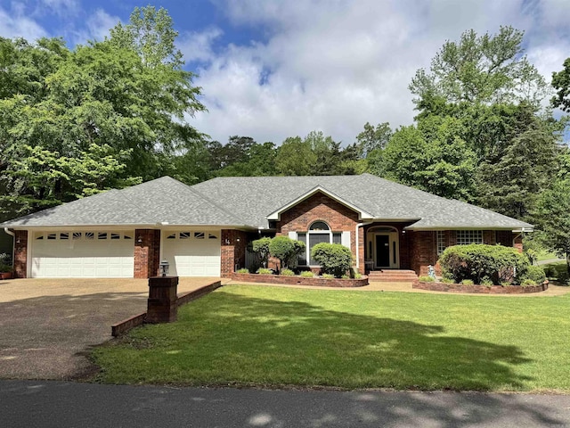 ranch-style house with aphalt driveway, a front yard, roof with shingles, brick siding, and an attached garage