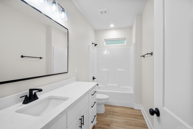 139 Hudson Dr, Sheridan, AR 72150 - bathroom featuring visible vents, vanity, wood finished floors, toilet, and washtub / shower combination