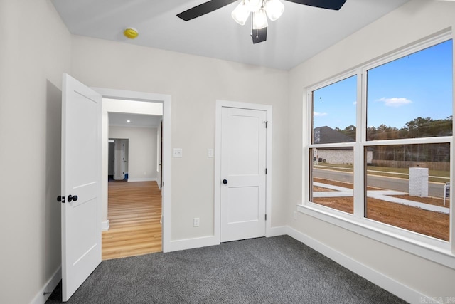 139 Hudson Dr, Sheridan, AR 72150 - unfurnished bedroom with baseboards, ceiling fan, and dark carpet