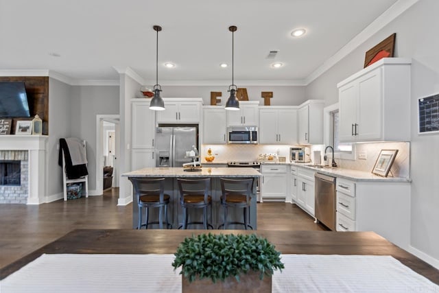 kitchen featuring backsplash, white cabinets, a breakfast bar, stainless steel appliances, and dark wood-type flooring