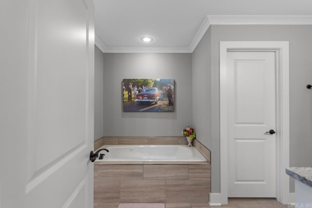 bathroom with a garden tub, ornamental molding, and recessed lighting