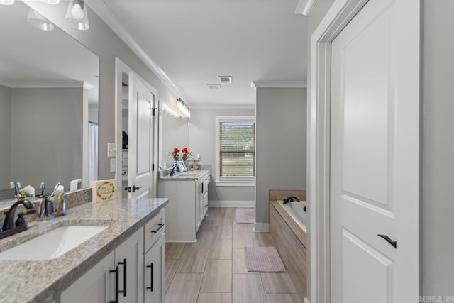 bathroom with crown molding, two vanities, a sink, and a garden tub