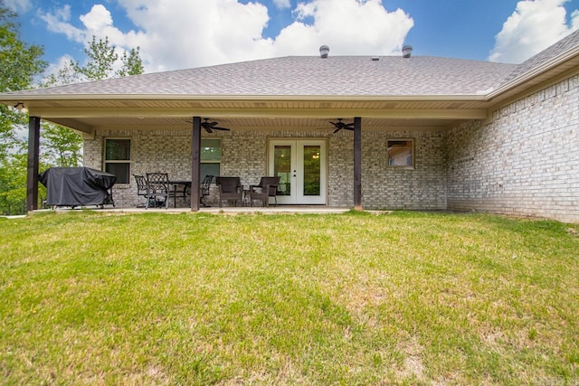 back of house with french doors, a ceiling fan, a yard, and brick siding