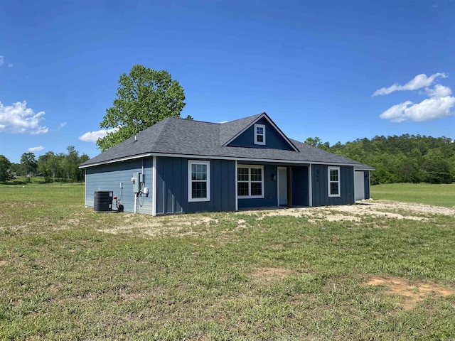 92 Revas Way, Story, AR 71970 - view of front of house with central AC unit, board and batten siding, a front yard, and a shingled roof