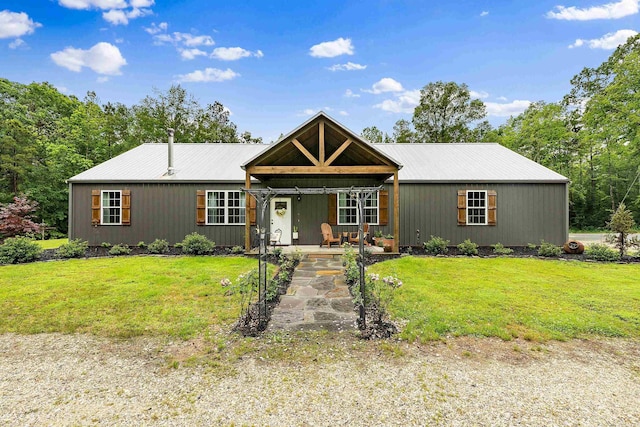 single story home featuring metal roof, a porch, and a front lawn