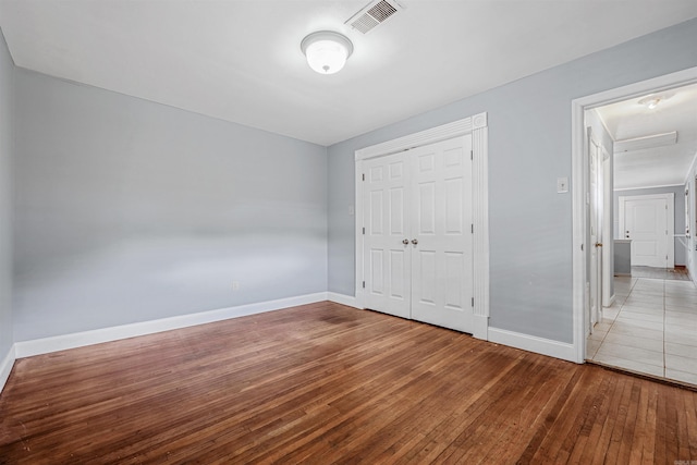 718 W 41st St, North Little Rock, AR 72118 - unfurnished bedroom with baseboards, visible vents, hardwood / wood-style flooring, and a closet