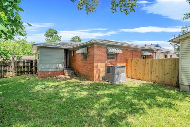 718 W 41st St, North Little Rock, AR 72118 - rear view of house featuring central AC, fence, brick siding, crawl space, and a yard