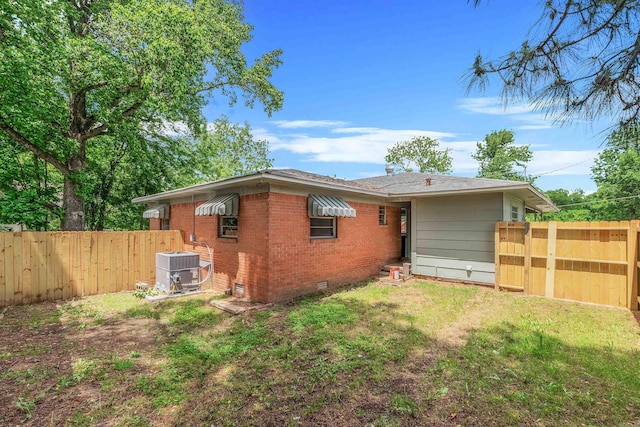 718 W 41st St, North Little Rock, AR 72118 - view of property exterior featuring crawl space, brick siding, central AC, fence, and a yard