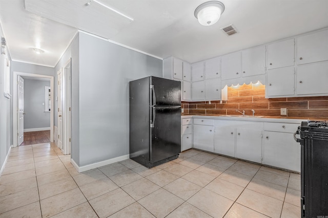 718 W 41st St, North Little Rock, AR 72118 - kitchen with white cabinets, light tile patterned floors, backsplash, visible vents, and black appliances
